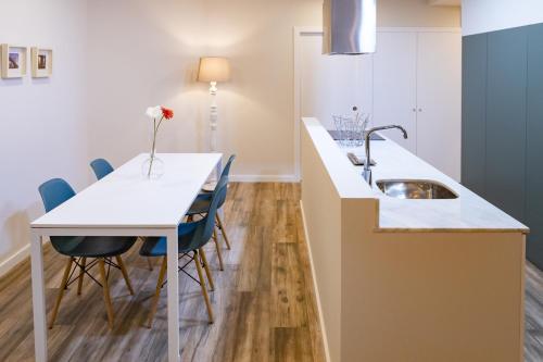 a kitchen with a sink and a table with chairs at Vale71house in Porto