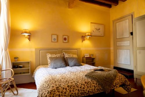 a bedroom with a bed and a yellow wall at Rue du Château in Tarascon