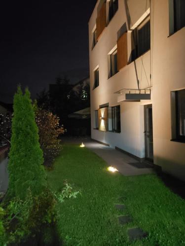 a large building with a grass yard at night at Panorama Business Inn in Cluj-Napoca