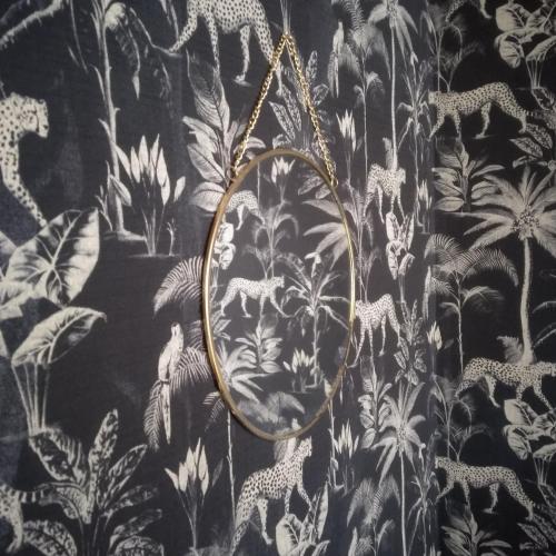 a mirror hanging on a black and white wallpaper at Rue du Château in Tarascon