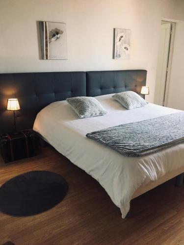 a bedroom with a large bed with white sheets and pillows at La Massonnière Gîte et chambres d'hôtes in Mondion