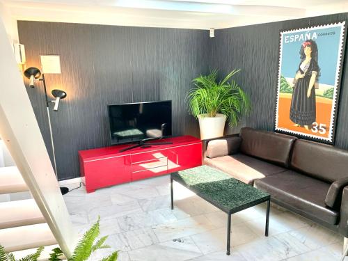 a living room with a couch and a tv at Apartamentos Puerta Del Sol in Madrid