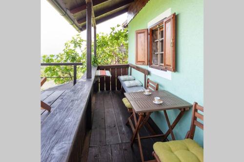 a wooden porch with a table and chairs on a balcony at Zidanica Lackner in Črnomelj