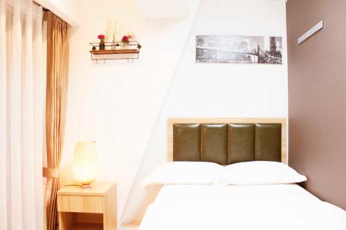 een slaapkamer met een wit bed en een raam bij Hotel Shu in Tokyo