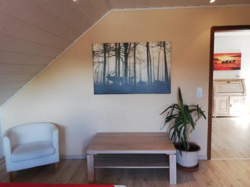 a room with a table and a chair and a painting at Goslar Ferienwohnung im Harz in Neuwallmoden