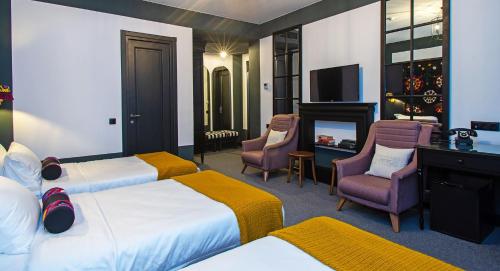 a hotel room with two beds and a television at Esquisse Design Hotel in Tʼelavi
