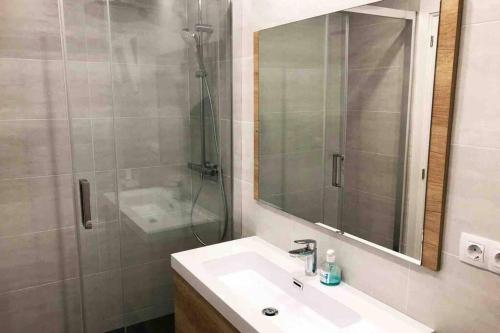 2 BEDROOM APARTMENT SANTS في برشلونة: حمام مع حوض ودش ومرآة