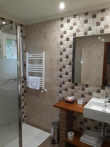 a bathroom with a sink and a shower at Casa Manoli Luarca in Almuña