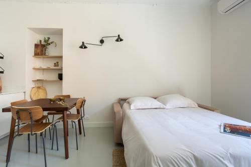 une chambre avec un lit, une table et des chaises dans l'établissement Plage à pied au cœur du vieil Antibes, à Antibes