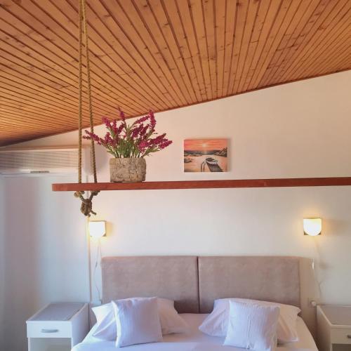 a bedroom with a bed with a potted plant above it at Rubin Jelsa in Jelsa
