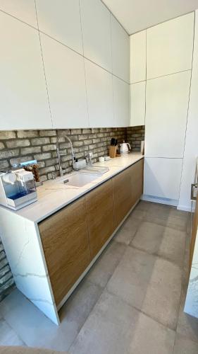 a kitchen with a sink and wooden cabinets at Apartament Blisko Natury in Tomaszkowo
