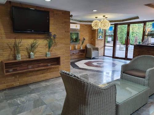 a living room with a flat screen tv on a wall at The Montana Lodge-Sathorn in Bangkok