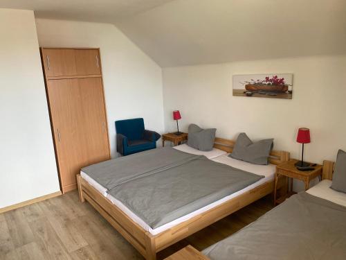 a bedroom with a bed and a blue chair at Ubytování U Kloučků v Potvorově in Potvorov