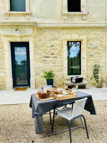 een tafel en twee stoelen voor een gebouw bij MAS DES 2 PLATANES in Arles