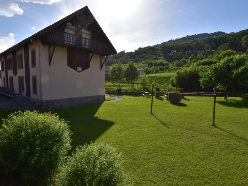 a house in a field with a grass yard at Apartment in La Bresse with Ski Storage Garden Terrace BBQ in La Bresse