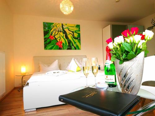a bedroom with a bed and a table with wine glasses and flowers at Pension Amo Marem in Dierhagen