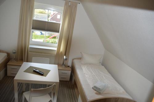 een kleine kamer met een bed en een raam bij Ferienhaus Tina in Wirdum