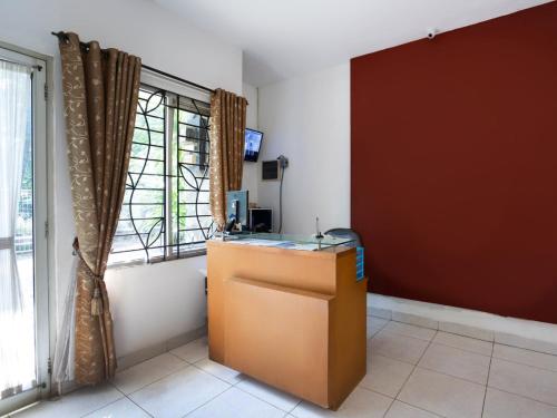 a room with a desk in front of a window at RedDoorz Syariah Plus @ Wisma Bougenville Karawaci in Tangerang