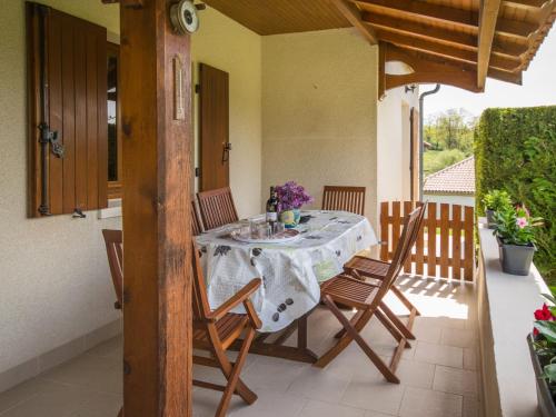 una mesa y sillas en el porche de una casa en Heritage holiday home with barbecue en Villefranche-du-Périgord