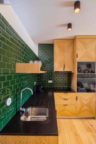 una cucina con lavello e parete di mattoni verdi di Casa do Rio a Mondim de Basto