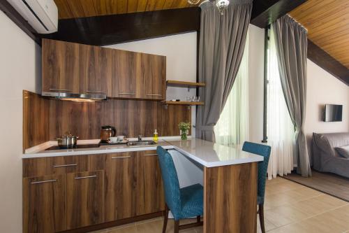 a kitchen with wooden cabinets and blue chairs at Shalet Greystone in Estosadok