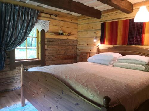 a bedroom with a bed in a log cabin at Kotka Farm in Saareküla