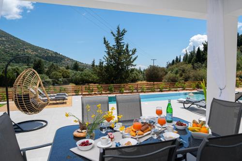 a table with food and drinks on a patio at Diosas Luxury Villas in Pilaroú