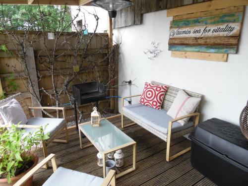un patio con sofás, sillas y una mesa. en The Den, en Egloskerry