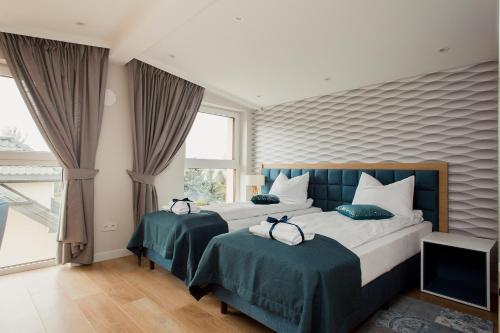 a bedroom with two beds and a large window at ShortStayPoland Apartamenty in Warsaw