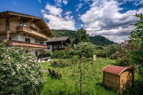 a house in the middle of a green field with a field at Alpine View Apartments in Niedernsill