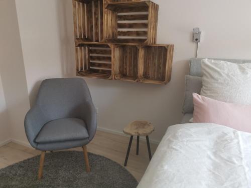 a bedroom with a chair next to a bed at harz-traum.2 in Gernrode - Harz