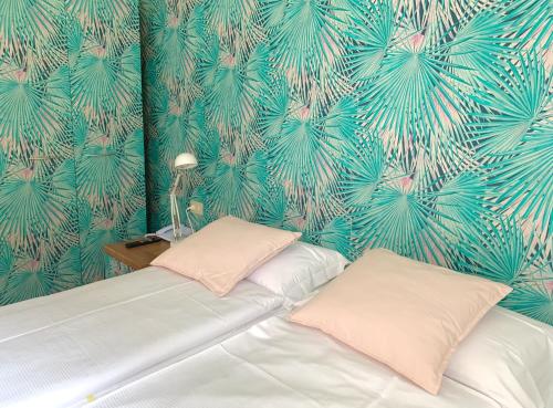 a bedroom with a bed with a tropical wallpaper at Ennesima Osteria con Alloggio - Bike Hotel in Toscolano Maderno
