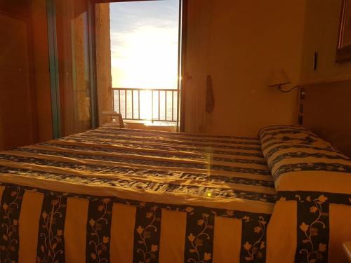 a large bed in a room with a window at Sea Palace Hotel in Marina di Fuscaldo