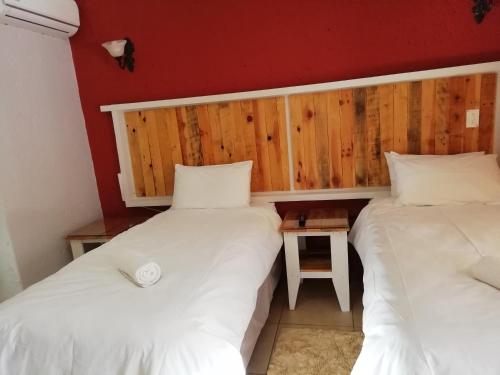two beds sitting next to each other in a room at The Doors Inn in Mokopane