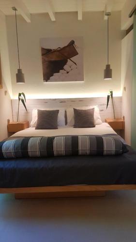 a bedroom with a large bed with two lamps at FEEL LIKE HOME IN LESVOS in Mytilini