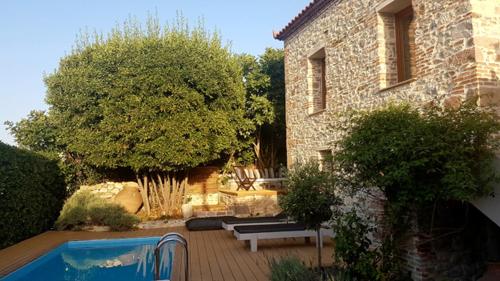 a garden with a pool and a building and a house at FEEL LIKE HOME IN LESVOS in Mytilene