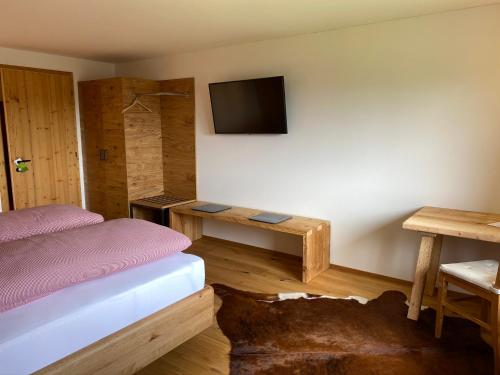 - une chambre avec un lit et une télévision murale dans l'établissement Gasthof Adler, à Doren