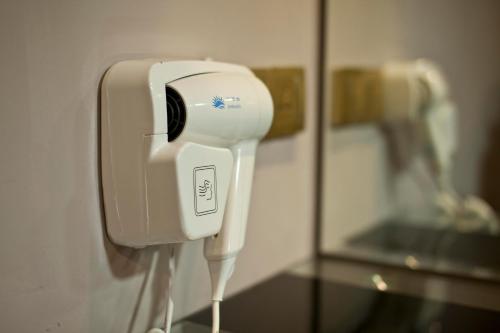 a hair dryer on a wall next to a mirror at Euro+ Hotel Johor Bahru in Johor Bahru