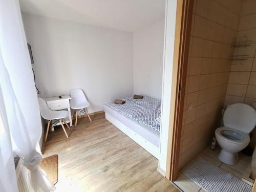 uma casa de banho com uma cama e um WC. em Poilsis Dzūkų 10 A em Palanga