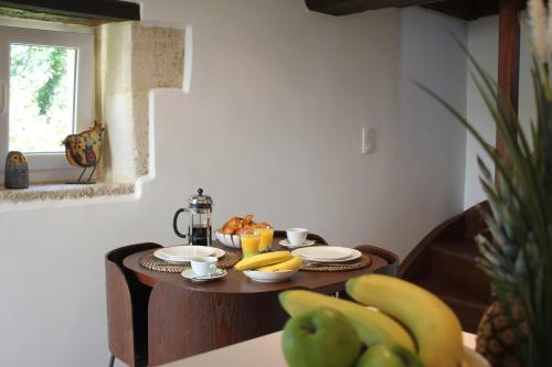 a table with bananas and cups on top of it at Cottage d'Exception - Coeur de Normandie in Vienne-en-Bessin
