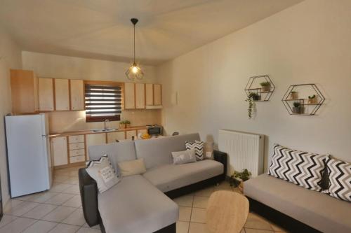 a living room with a couch and a kitchen at Aegean Emerald in Azolimnos