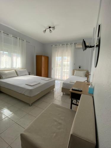 a large bedroom with two beds and a table at Rooms Magnolia in Nea Vrasna