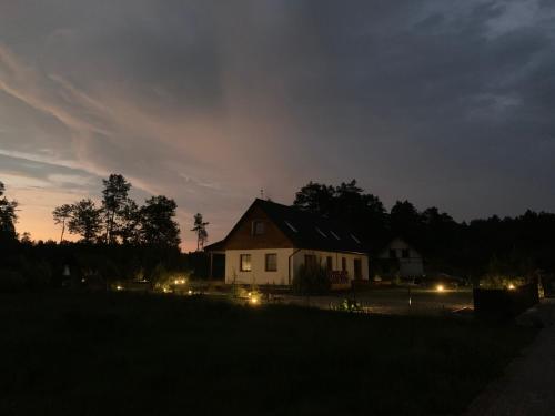 a house with lights in a field at night at Nad Wiartlem in Wiartel