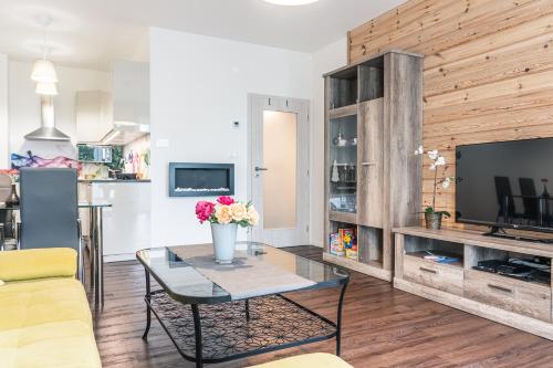 a living room with a table and a tv at Apartment Lucy - Primo Tatry Starý Smokovec in Smokovce