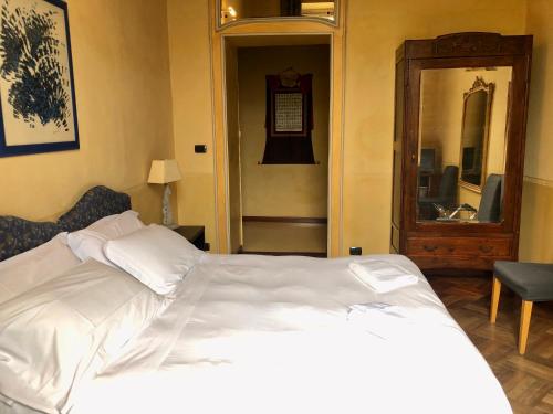 a bedroom with a white bed and a mirror at B&B Saluzzo Paesana 1718 in Turin