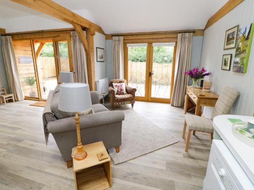 a living room with a couch and a chair at Goose Lodge in Shipston on Stour