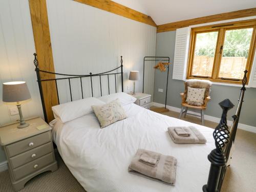 a bedroom with a large white bed with towels on it at Goose Lodge in Shipston on Stour