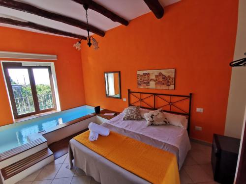 a bedroom with orange walls and a bed and a tub at Patrizia Casa Vacanze in Sant'Agnello