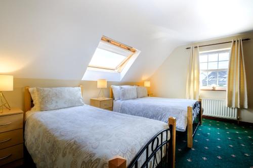 a bedroom with two beds and a window at Fallon's B&B in Kinvara