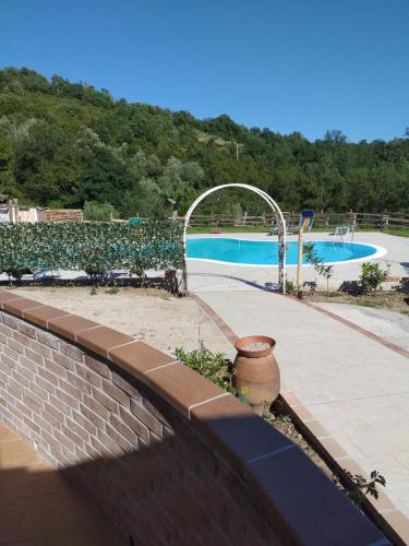 a brick retaining wall next to a swimming pool at Agriturismo Spinaruccoli in Cicerale